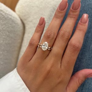 Elegant oval diamond solitaire engagement ring stacked with marquise and round diamond accent band