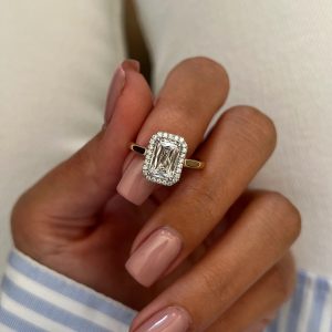 Emerald-shaped halo engagement ring with plain polished band