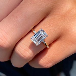 Emerald cut diamond halo engagement ring with pave band, front view