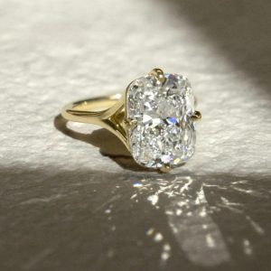 Elongated cushion-cut solitaire engagement ring with four-prong setting on a plain tapered band