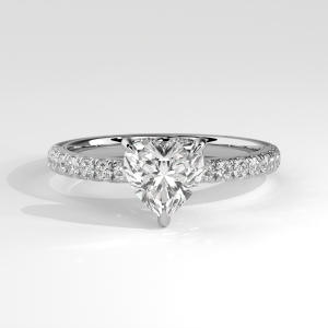 Heart-shaped diamond engagement ring with pavé band and elegant basket setting